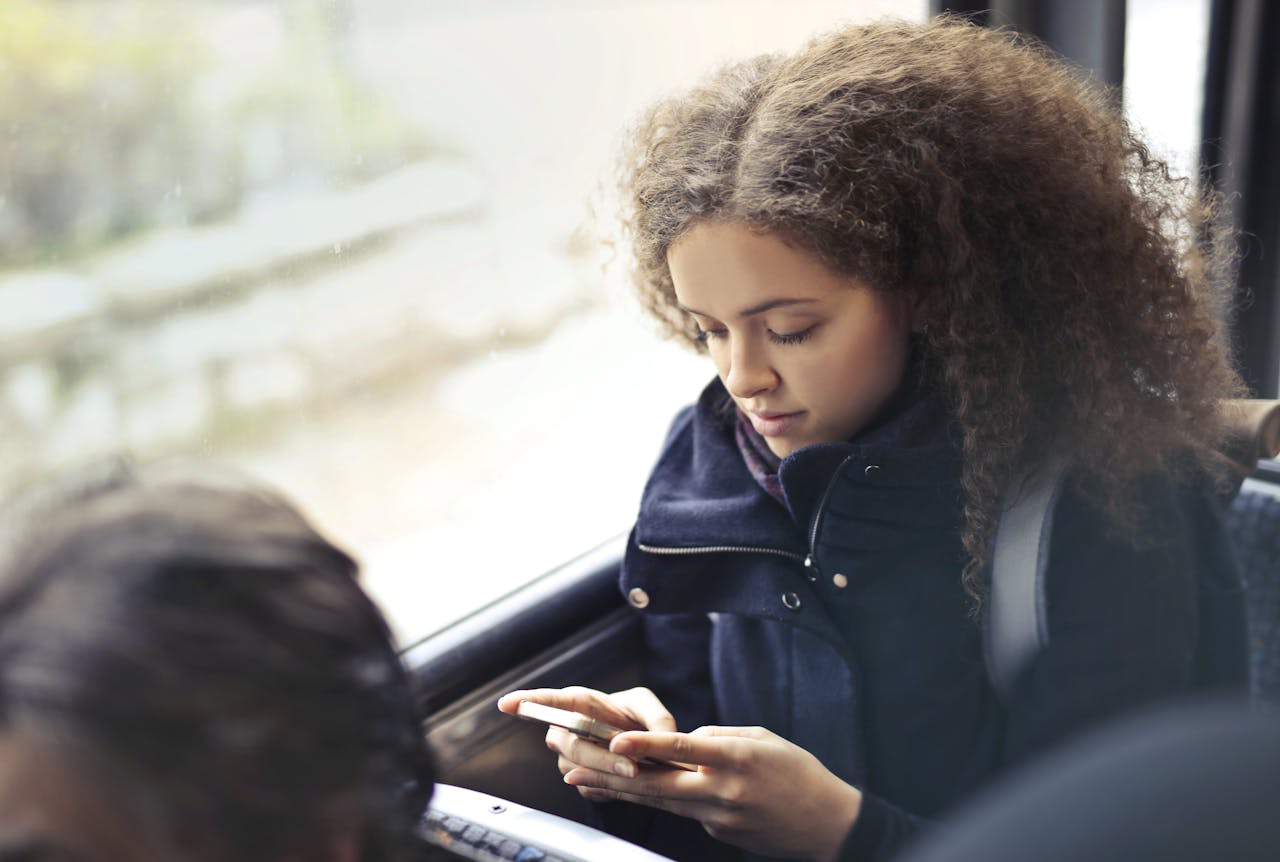 Une fille qui écrit un texto dans un bus