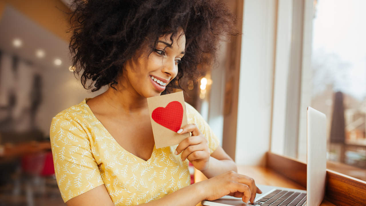 Une fille avec un objet en forme de coeur devant un ordinateur portable