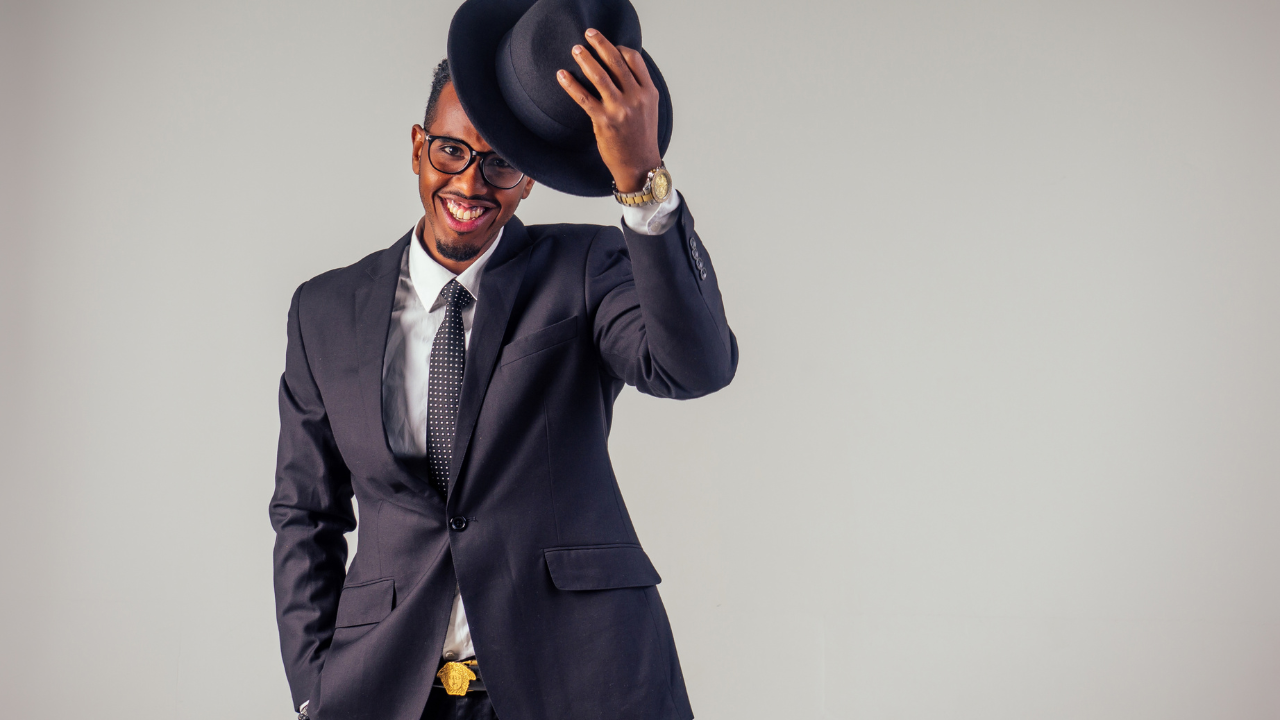 Un homme africain bien habillé avec un chapeau à la main