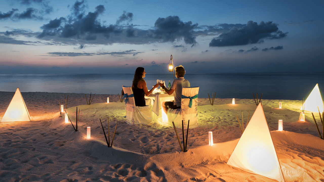 Un couple dine en romantique sur une plage