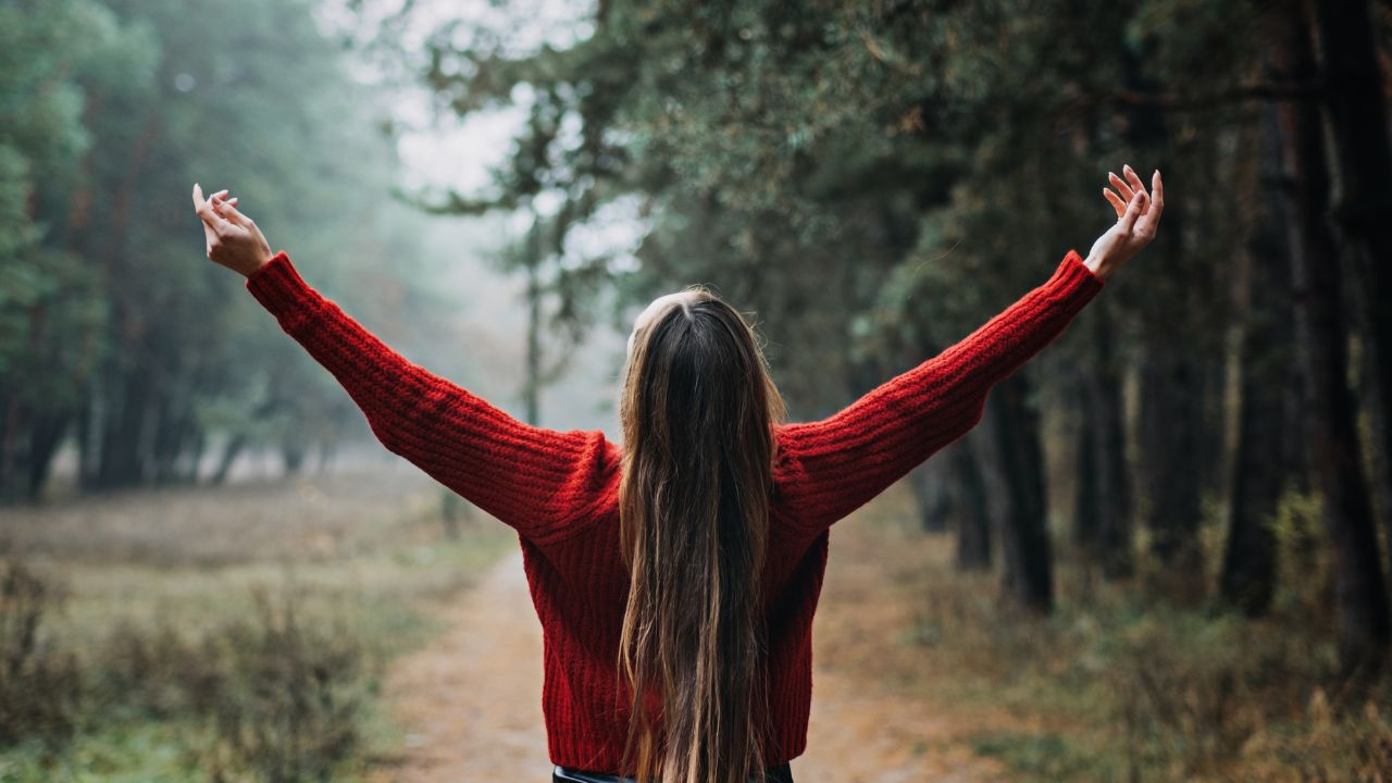 Une femme les bras ouverts à la campagne