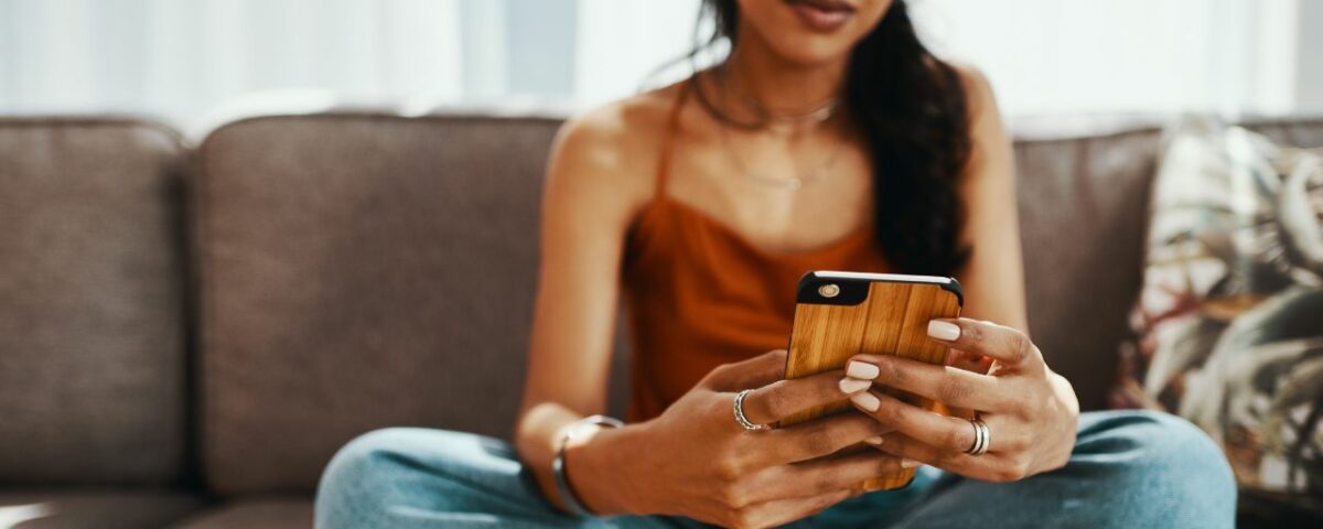 Une femme métisse qui est en train d'écrire un message sur un site de rencontre